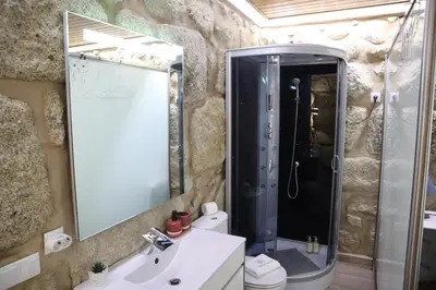 a bathroom with a shower and a sink and a mirror at Boavista Rustic House in Porto