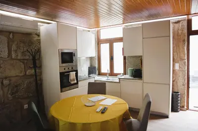 a kitchen and dining room with a yellow table and chairs at Boavista Rustic House in Porto