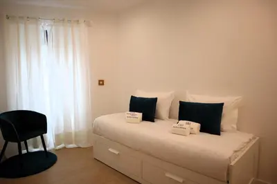 a bedroom with a bed with black and white pillows at Francos Family House in Porto