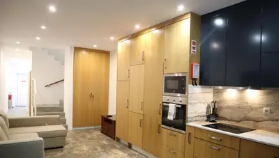 a kitchen with wooden cabinets and a stove top oven at Francos Family House in Porto