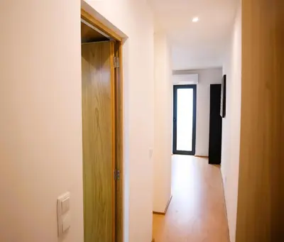 an empty hallway with a wooden door and a hallway at Francos Family House in Porto