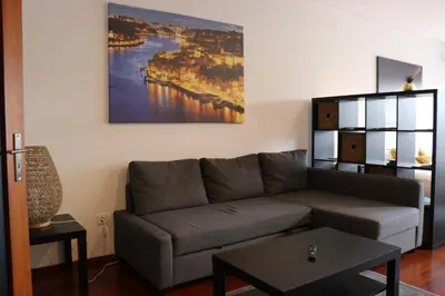 a living room with a couch and a painting on the wall at Estudio Metro heroismo in Porto