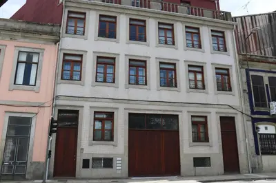 a white building with red doors on a city street at Estudio Metro heroismo in Porto