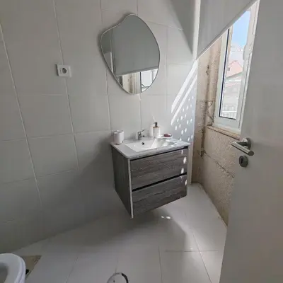 a white bathroom with a sink and a mirror at Grandma aparts in Porto