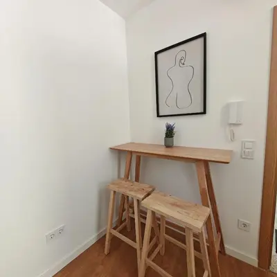 a table and two stools in a room at Grandma aparts in Porto