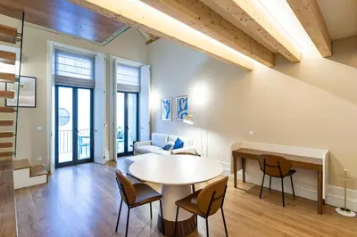 a living room with a table and chairs at ApartmentsPorto - Almada 318 in Porto