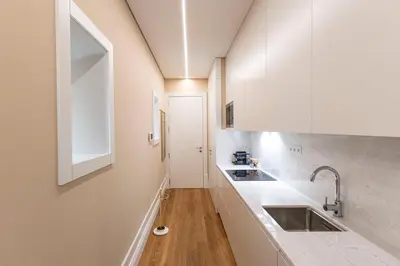 a kitchen with white cabinets and a sink at ApartmentsPorto - Almada 318 in Porto