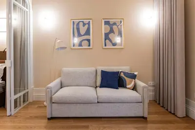 a couch in a living room with three pictures on the wall at ApartmentsPorto - Almada 318 in Porto