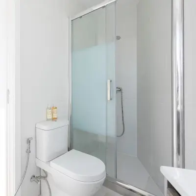 a bathroom with a toilet and a glass shower at Aparts d'Avó in Porto