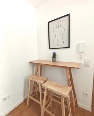 a wooden table and two stools in a room at Aparts d'Avó in Porto
