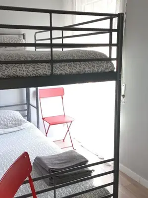 a bedroom with two bunk beds and a chair at Lulapartment in Porto