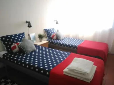 two beds in a room with red white and blue at Lulapartment in Porto