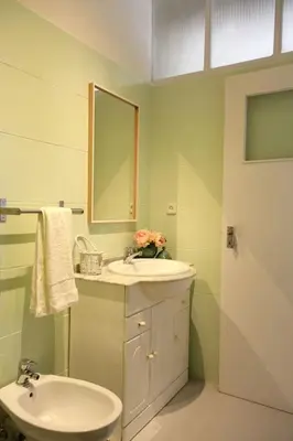 a bathroom with a sink and a toilet and a mirror at Lulapartment in Porto