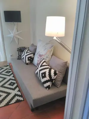 a living room with a couch with pillows and a lamp at Lulapartment in Porto