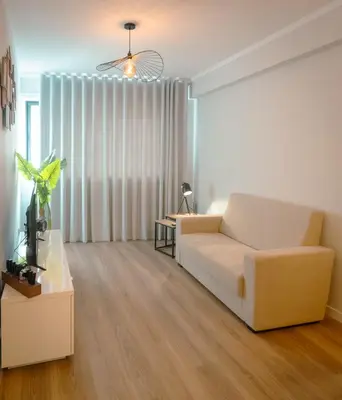 a living room with a white couch and a table at The Cale - Antero de Quental - 21 in Porto