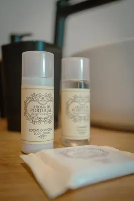 two bottles of moisturizers sitting on a wooden table at The Cale - Antero de Quental 32 in Porto