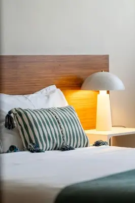 a bed with a pillow and a lamp on it at Julio Dinis Studio in Porto