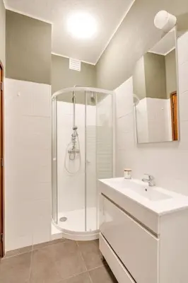 a white bathroom with a shower and a sink at Julio Dinis Studio in Porto