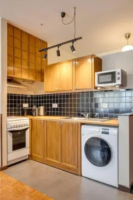 a kitchen with a washing machine and a microwave at Julio Dinis Studio in Porto