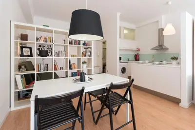 a kitchen and dining room with a white table and chairs at BmyGuest - Santa Catarina's Loft in Porto