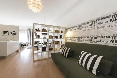 a living room with a green couch and a wall at BmyGuest - Santa Catarina's Loft in Porto