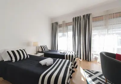 a bedroom with two beds and a window at BmyGuest - Santa Catarina's Loft in Porto