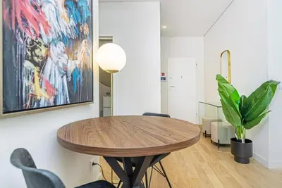 a dining room with a wooden table and a painting at Paraíso 57 D in Porto