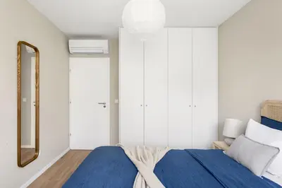 a bedroom with a blue bed and a mirror at Wonderful 2BR Apartment in Boavista by LovelyStay in Porto