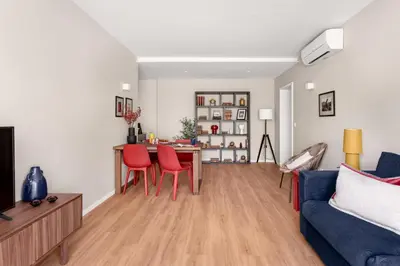 a living room with a blue couch and red chairs at Wonderful 2BR Apartment in Boavista by LovelyStay in Porto