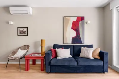 a living room with a blue couch and a red table at Wonderful 2BR Apartment in Boavista by LovelyStay in Porto