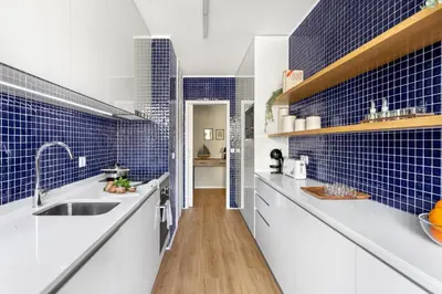a kitchen with white counters and blue tiles at Wonderful 2BR Apartment in Boavista by LovelyStay in Porto