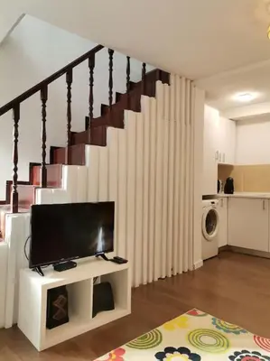 a living room with a tv and a staircase at Casa Cadu - Porto in Porto