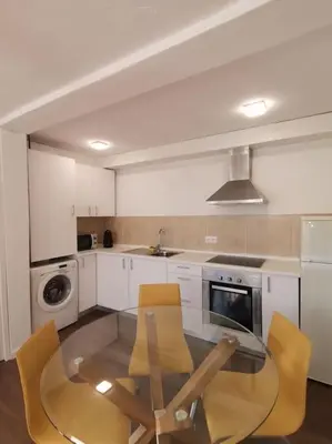 a kitchen with a glass table and yellow chairs at Casa Cadu - Porto in Porto