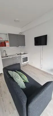 a living room with a couch and a kitchen at Green Studio in Porto