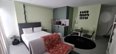 a bedroom with a white bed and a table and chairs at Green Studio in Porto
