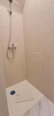 a bathroom with a shower with a white towel at Green Studio in Porto