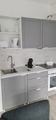 a white kitchen with a sink and a counter top at Green Studio in Porto