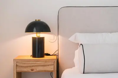 a black lamp on a night stand next to a bed at GuestReady - A peaceful home near downtown in Porto