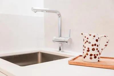 a polka dot cup sitting on a cutting board next to a sink at GuestReady - A peaceful home near downtown in Porto