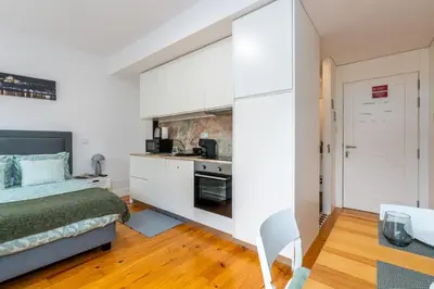 a small bedroom with a bed and a kitchen at A Window to Porto - Premium Studio at Clérigos Tower in Porto