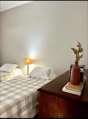 a bedroom with two beds and a table with a vase at Porto Vintage House in Porto
