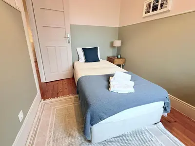 a small bedroom with a bed with towels on it at Porto Vintage House in Porto