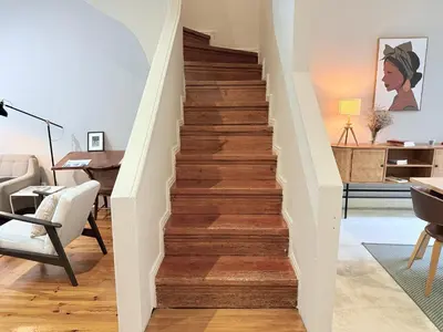 a staircase in a living room with wood floors at Porto Vintage House in Porto