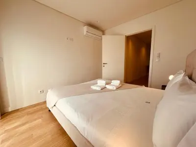 a bedroom with a large white bed with towels on it at Paraíso P in Porto