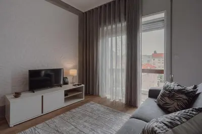 a living room with a couch and a television at 1BR w/ AC near Palácio de Cristal in Porto