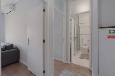 a living room with a couch and a bathroom at 1BR w/ AC near Palácio de Cristal in Porto