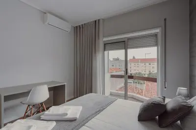 a bedroom with a bed and a large window at 1BR w/ AC near Palácio de Cristal in Porto