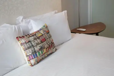 a white bed with a pillow on top of it at Trindade Premium Suites & Apartments in Porto