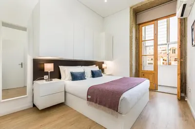 a white bedroom with a large bed and a window at Apartment Bolhao Market by Sweet Porto in Porto