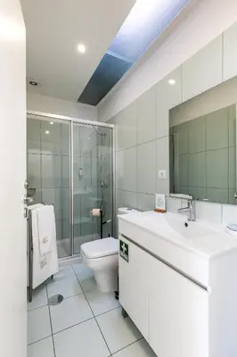 a white bathroom with a toilet and a sink at Apartment Bolhao Market by Sweet Porto in Porto